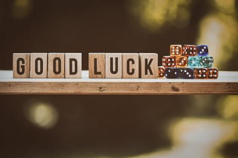 Wooden blocks spelling GOOD LUCK next to dice pile