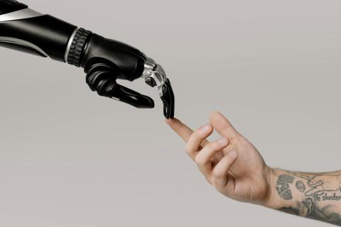 The fingertip of a human arm touches the fingertip of a robotic arm The fingertip of a human arms touches the fingertip of a robotic arm