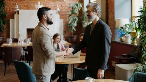 Two men shaking hands in a coffee shop