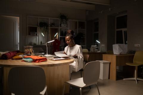 Girl at desk alone in dark office at night