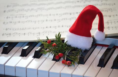 Sheet music and tiny Santa hat on piano keys