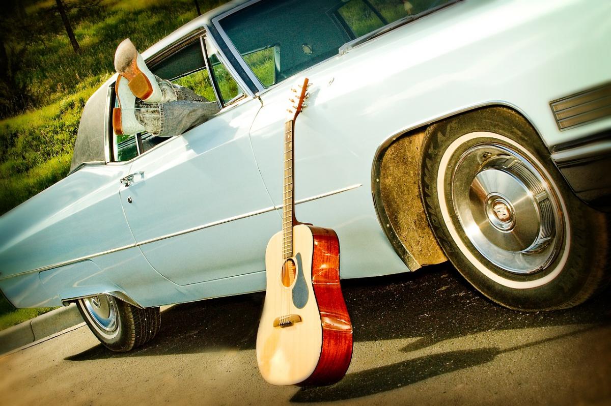 Musician laying in back seat of car with feet up