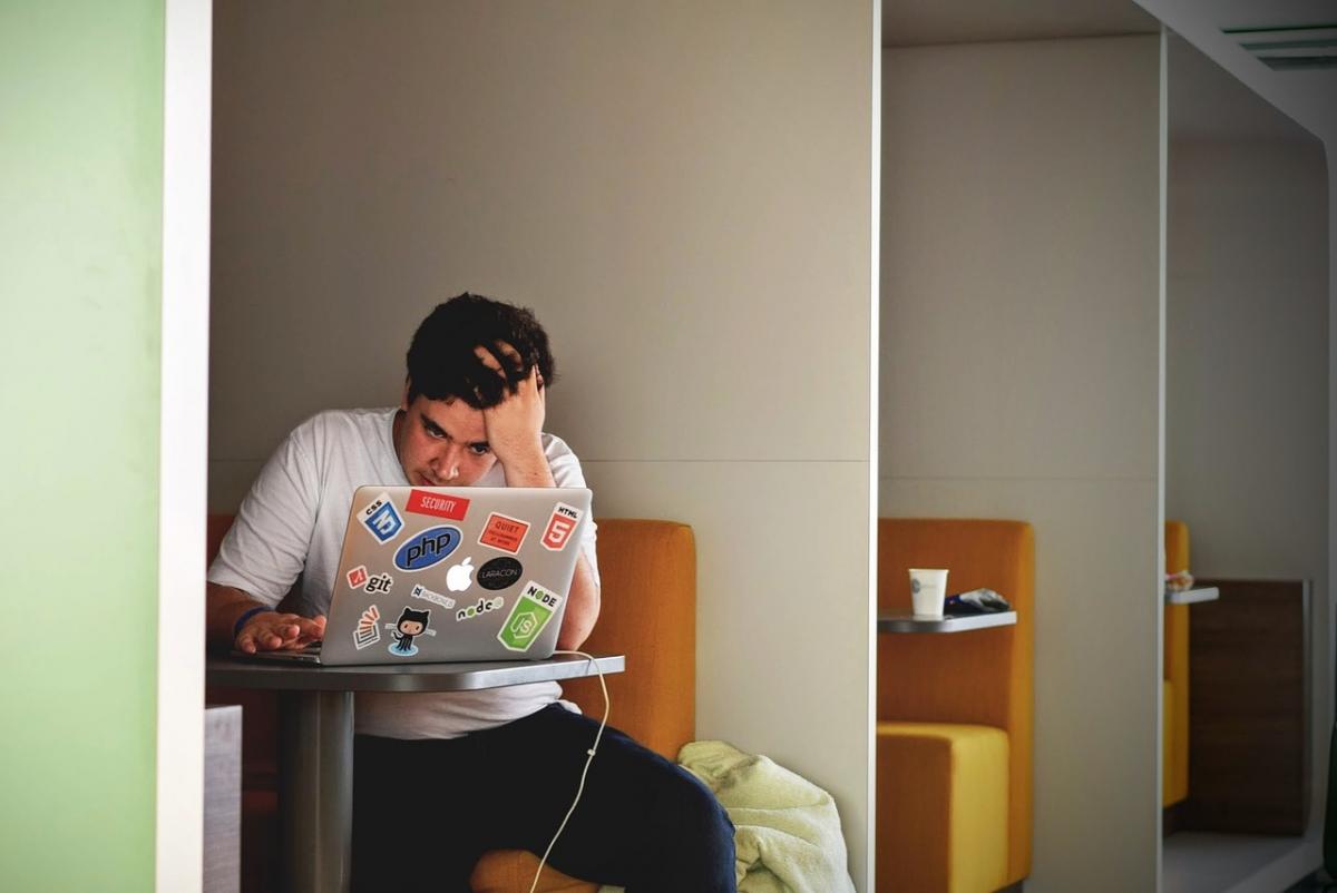 Guy with Head in Hand Looking at Laptop