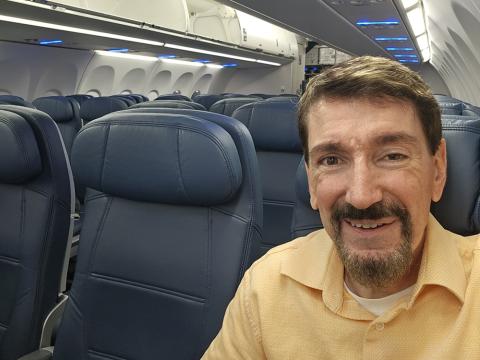 Bruce Wawrzyniak sitting in his seat on an airplane, empty at the time