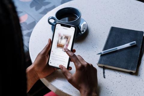 Girl's hands holding smartphone showing an Instagram post