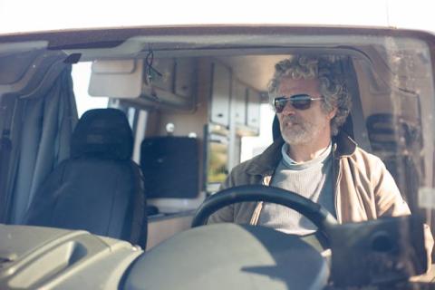 Man wearing sunglasses driving a conversion van