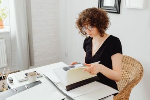 Girl seated in home office looking at a file