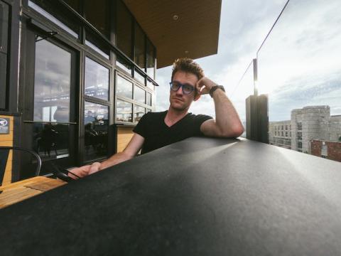 Frustrated guy waiting alone at outside table