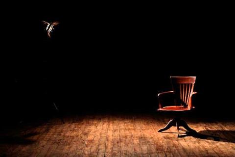 A chair on an empty dark stage