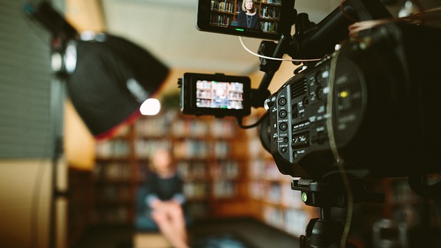 Video camera filming woman at bookshelves